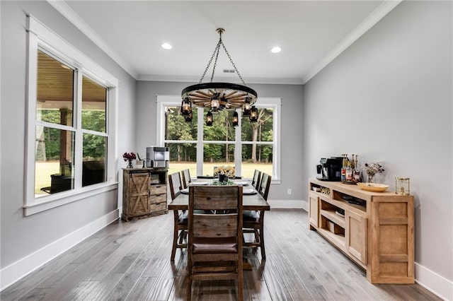 dining area featuring crown molding, hardwood / wood-style flooring, and an inviting chandelier