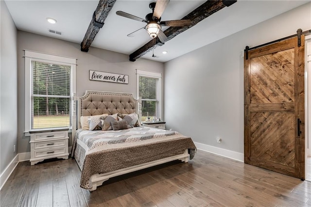 bedroom with hardwood / wood-style flooring, ceiling fan, a barn door, and beamed ceiling