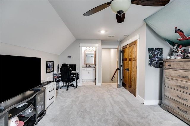 office featuring vaulted ceiling, light carpet, and ceiling fan