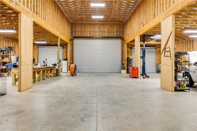 garage featuring a workshop area and wood walls