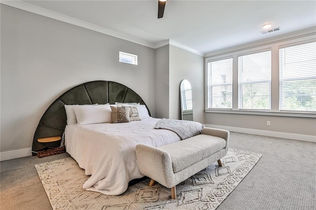 carpeted bedroom featuring visible vents, a ceiling fan, crown molding, and baseboards