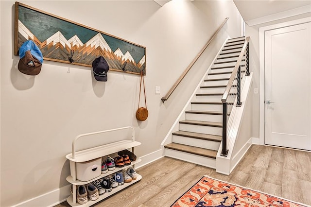 stairway with wood finished floors and baseboards