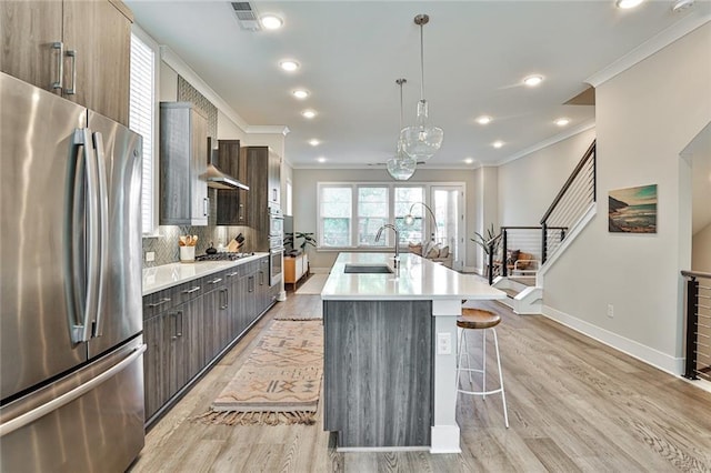 kitchen featuring light countertops, a kitchen breakfast bar, light wood-style flooring, and appliances with stainless steel finishes