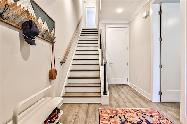 staircase featuring baseboards and wood finished floors