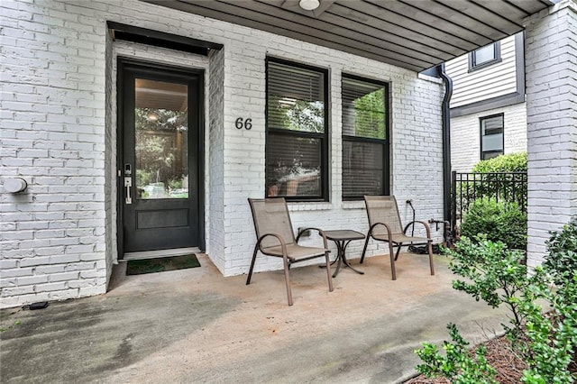 entrance to property with brick siding and covered porch