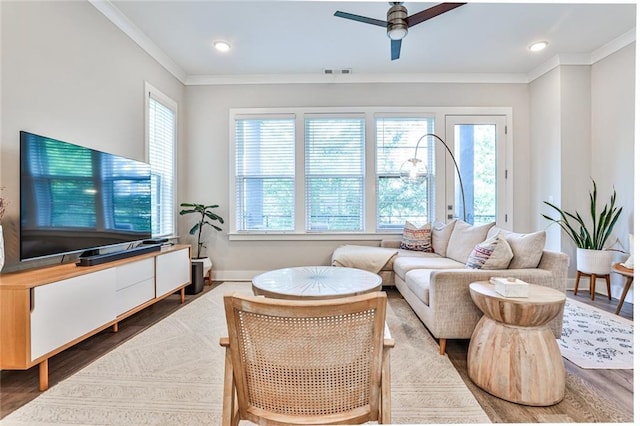 living area with plenty of natural light, ornamental molding, and dark wood-style flooring