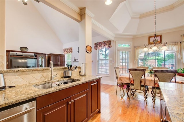 kitchen featuring a raised ceiling, sink, light stone countertops, and light hardwood / wood-style floors