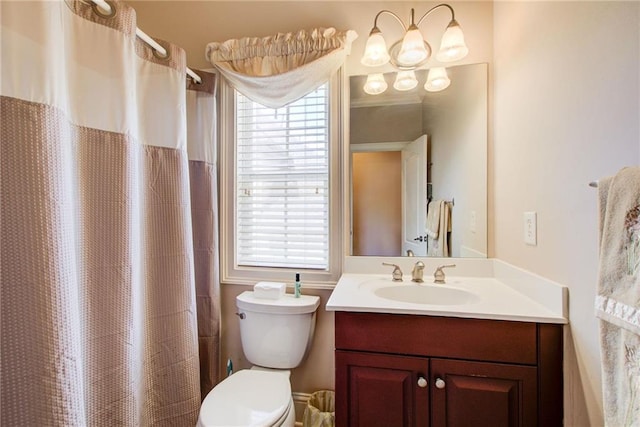 bathroom featuring a shower with shower curtain, vanity, toilet, and a healthy amount of sunlight