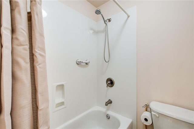 bathroom featuring toilet and shower / tub combo with curtain