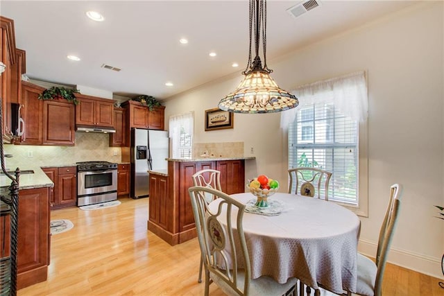 dining space featuring light hardwood / wood-style flooring and ornamental molding