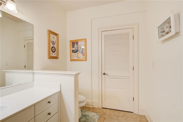 bathroom featuring tile patterned flooring, toilet, and vanity