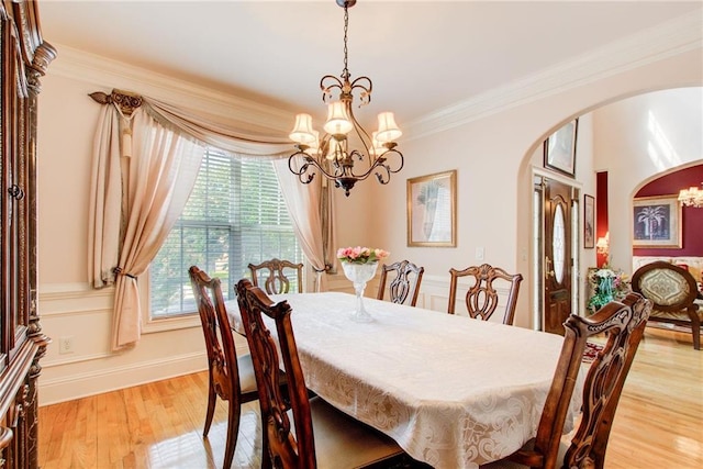 dining room with ornamental molding, a chandelier, and light hardwood / wood-style floors