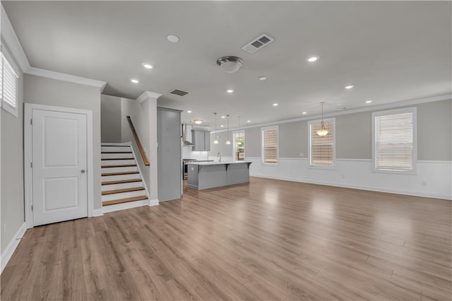 1179 Bennett Creek Overlook, Suwanee, GA 30024 - unfurnished living room with ornamental molding, stairway, light wood-type flooring, recessed lighting, and a sink