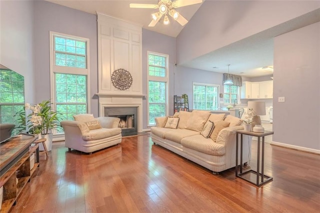 2022 Maple Ridge Dr NW, Acworth, GA 30101 - living room with a ceiling fan, hardwood / wood-style floors, high vaulted ceiling, a large fireplace, and baseboards