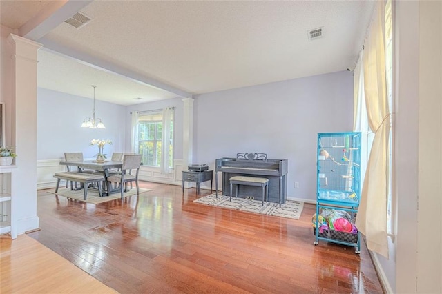 2022 Maple Ridge Dr NW, Acworth, GA 30101 - living area featuring wood finished floors, decorative columns, a chandelier, and baseboards