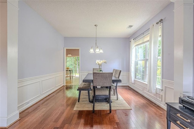 2022 Maple Ridge Dr NW, Acworth, GA 30101 - dining area featuring a textured ceiling, hardwood / wood-style flooring, a wainscoted wall, a chandelier, and a decorative wall