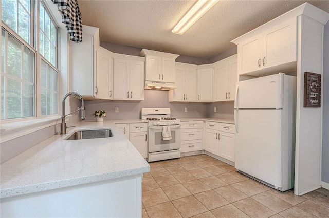 2022 Maple Ridge Dr NW, Acworth, GA 30101 - kitchen with white appliances, under cabinet range hood, a sink, a textured ceiling, and light tile patterned floors