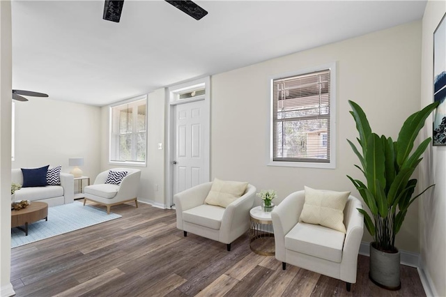 living area featuring dark wood-style flooring, a healthy amount of sunlight, and ceiling fan