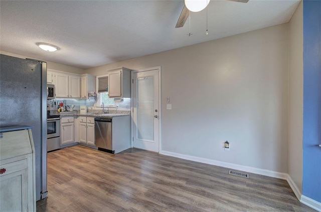 80 Broadlands Dr, White, GA 30184 - kitchen with appliances with stainless steel finishes, ceiling fan, wood finished floors, light countertops, and a textured ceiling