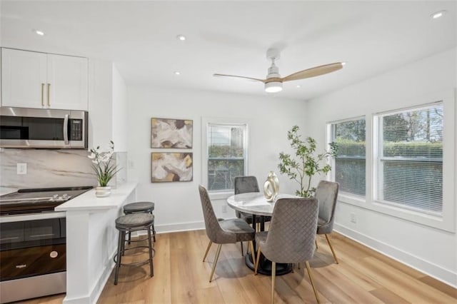 dining room with ceiling fan and light hardwood / wood-style floors