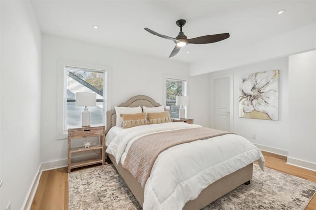 bedroom featuring multiple windows, ceiling fan, and light hardwood / wood-style flooring