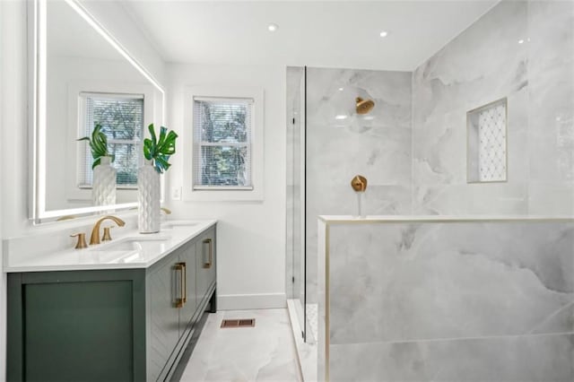 bathroom with tiled shower and vanity