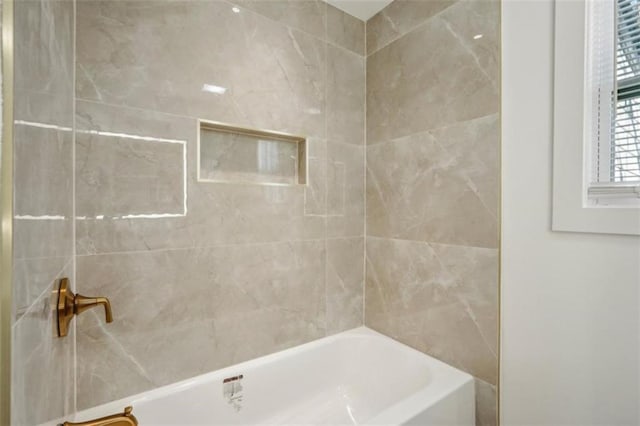 bathroom featuring tiled shower / bath