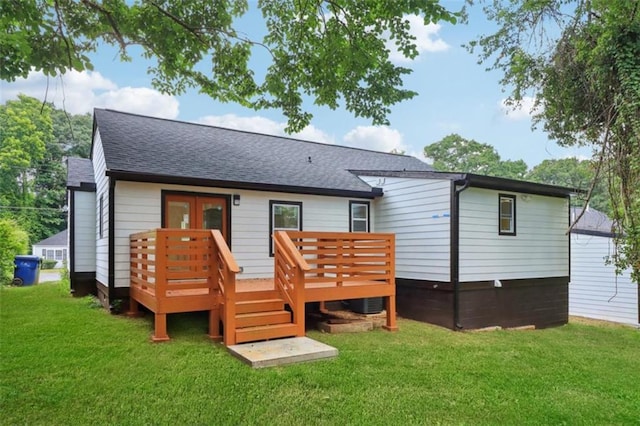 rear view of property featuring french doors, a lawn, and a wooden deck