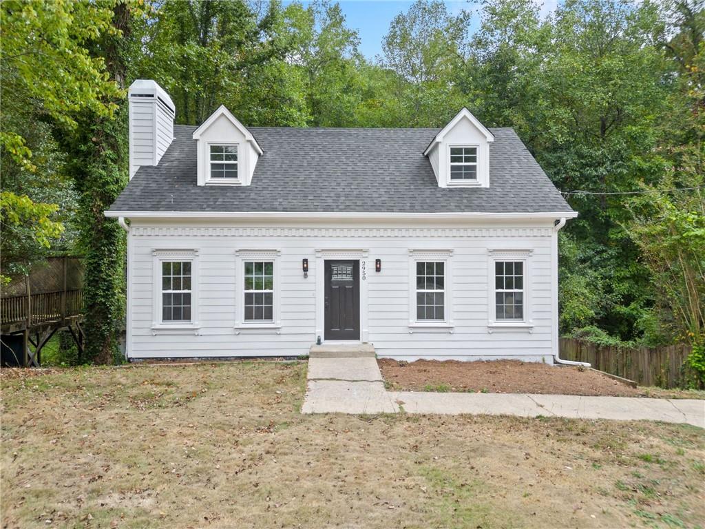 cape cod-style house with a front lawn