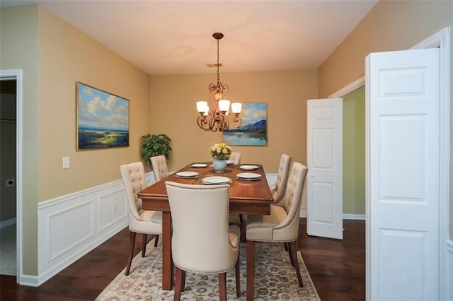 dining area featuring dark wood-type flooring and a chandelier