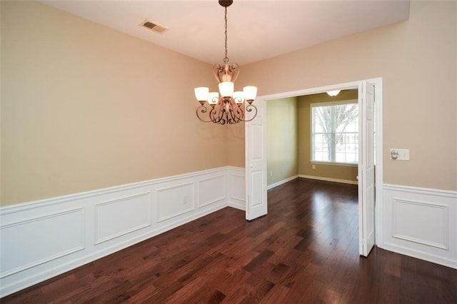 unfurnished dining area with an inviting chandelier and dark hardwood / wood-style floors