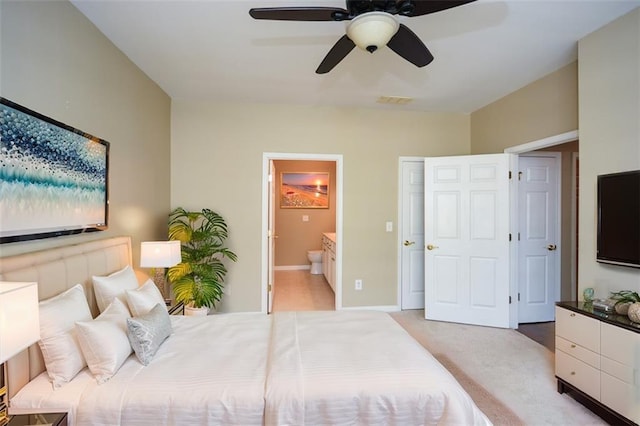 carpeted bedroom with ceiling fan and ensuite bath