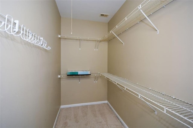 walk in closet featuring light colored carpet