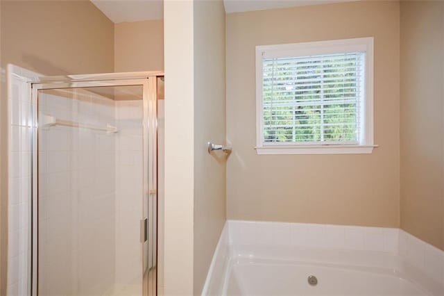 bathroom featuring shower with separate bathtub