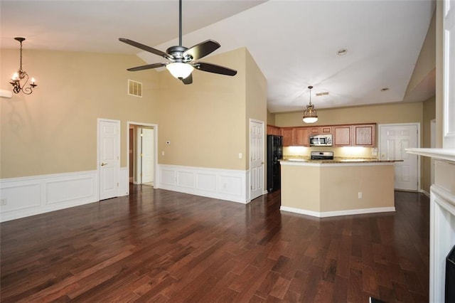 kitchen with range, black fridge, dark hardwood / wood-style flooring, ceiling fan with notable chandelier, and vaulted ceiling