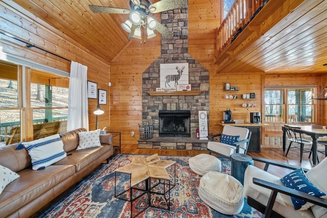 living area with wood ceiling, lofted ceiling, wooden walls, and a healthy amount of sunlight