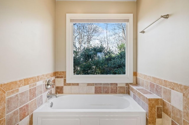 bathroom with a garden tub and tile walls