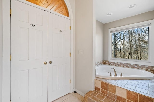 full bathroom featuring tile patterned flooring and a garden tub