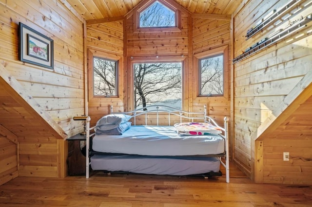 bedroom with vaulted ceiling, wood ceiling, and wood walls