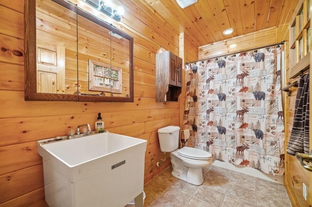 full bath featuring a sink, toilet, wood ceiling, and wood walls