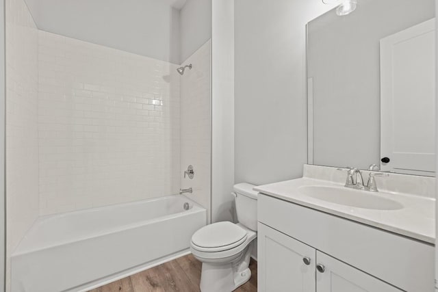 full bath with washtub / shower combination, vanity, wood finished floors, and toilet