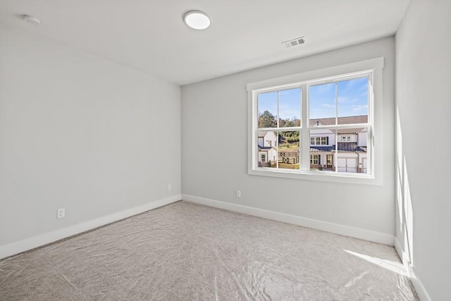 carpeted spare room with baseboards and visible vents