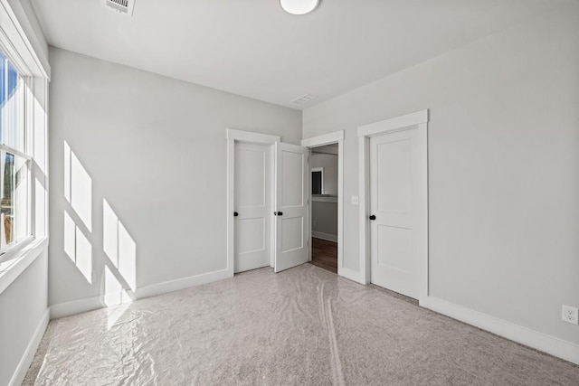 unfurnished bedroom featuring visible vents and baseboards