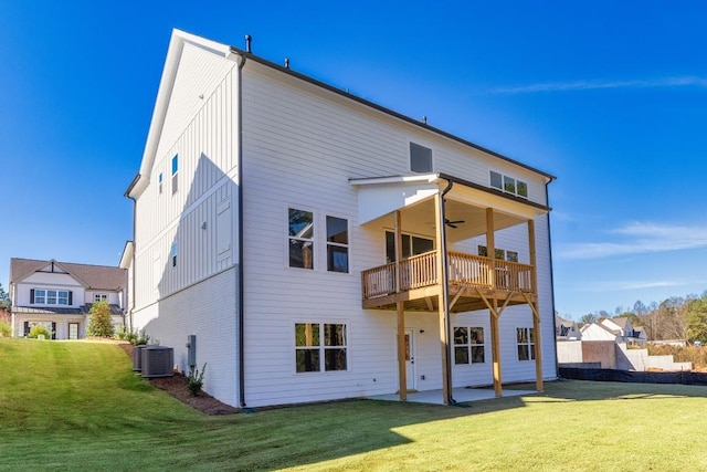 back of property with ceiling fan, a patio, a lawn, and board and batten siding