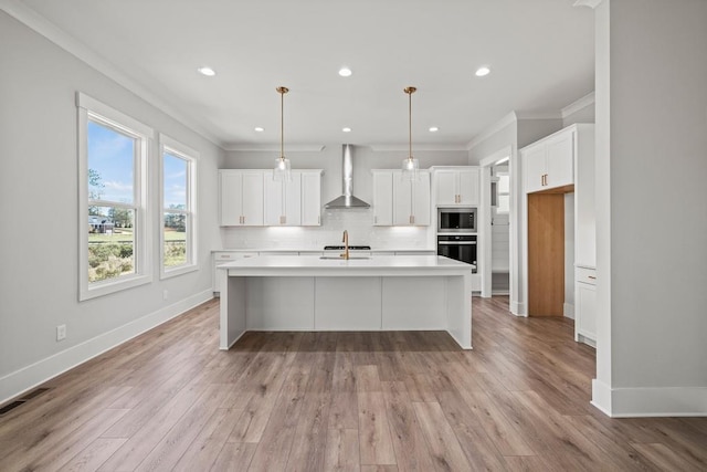 kitchen with tasteful backsplash, light wood-style flooring, wall chimney range hood, built in microwave, and oven