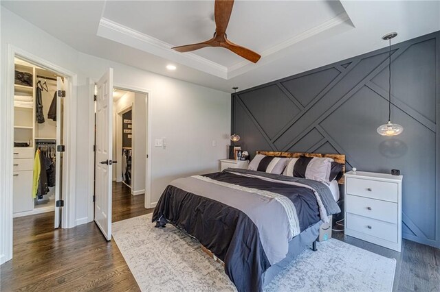 2164 Mill Garden Run, Buford, GA 30519 - bedroom with dark wood-style flooring, a tray ceiling, a spacious closet, and ornamental molding