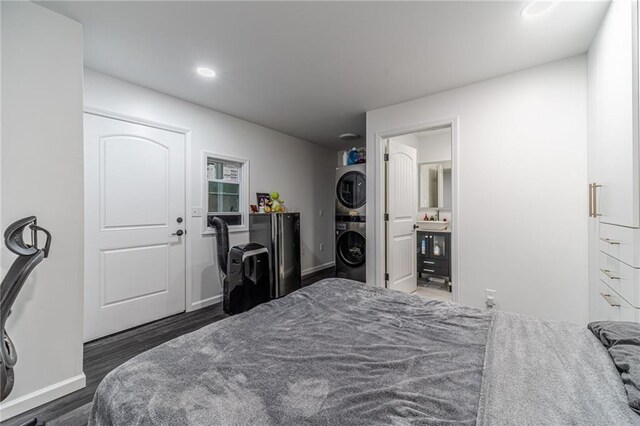 2164 Mill Garden Run, Buford, GA 30519 - bedroom featuring baseboards, stacked washer and clothes dryer, freestanding refrigerator, a sink, and wood finished floors