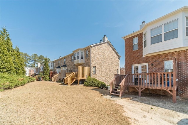 2164 Mill Garden Run, Buford, GA 30519 - back of house featuring brick siding, a deck, and a chimney
