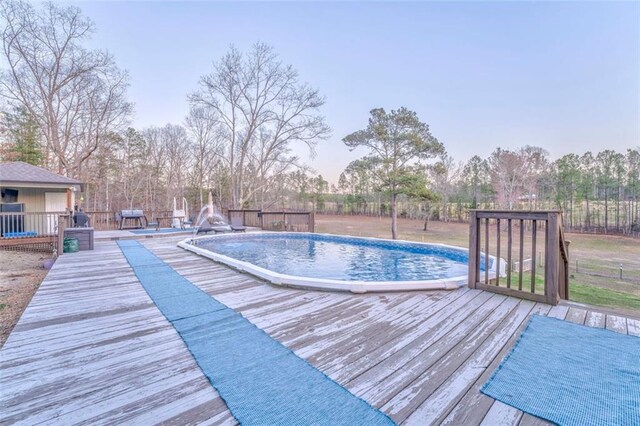 view of swimming pool with a wooden deck and a fenced in pool