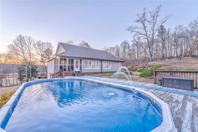 view of swimming pool with a fenced in pool, a deck, and a sunroom